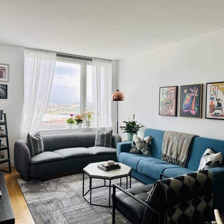 Colorful artwork displayed over sofa in living room with one lightly painted green wall.