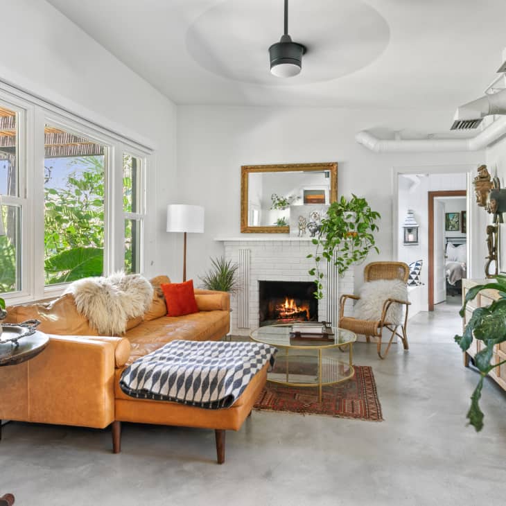 white living room with tan leather sofa and fireplace