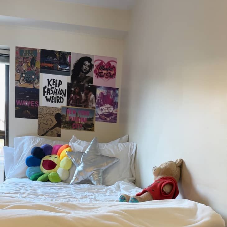 Bed in white dorm room with colorful art above