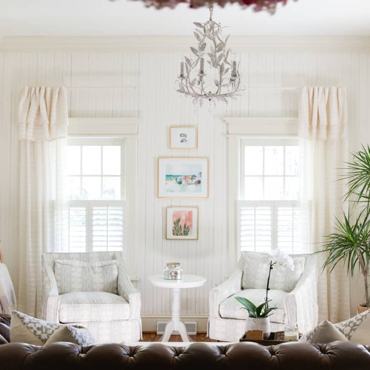 White living room with throws draped over rungs of leaning ladder
