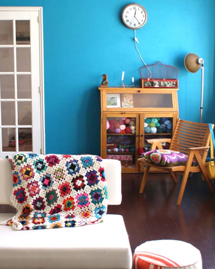 Cozy living room with blue wall, crochet blanket on