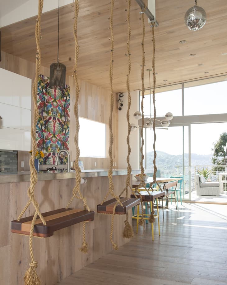 Kitchen with swing seats at the counter, colorful backsplash, and large windows overlooking a scenic view.