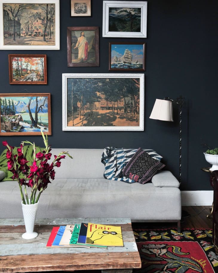 A dark gray wall with a gallery of photos and illustrations on it