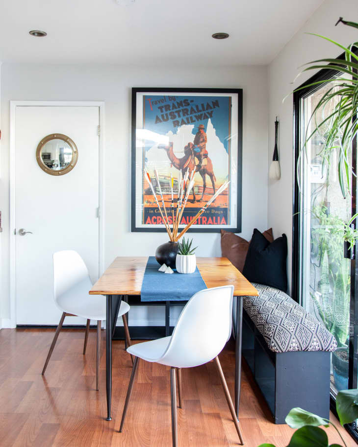 small living room with white chairs and camel painting