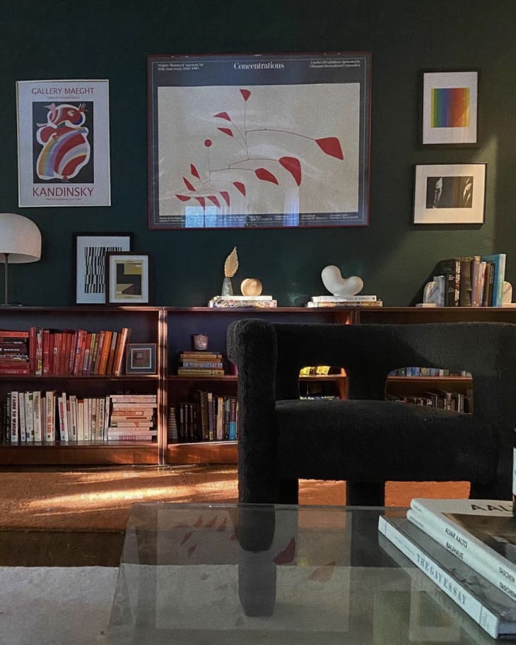 Green room with bookshelves and art