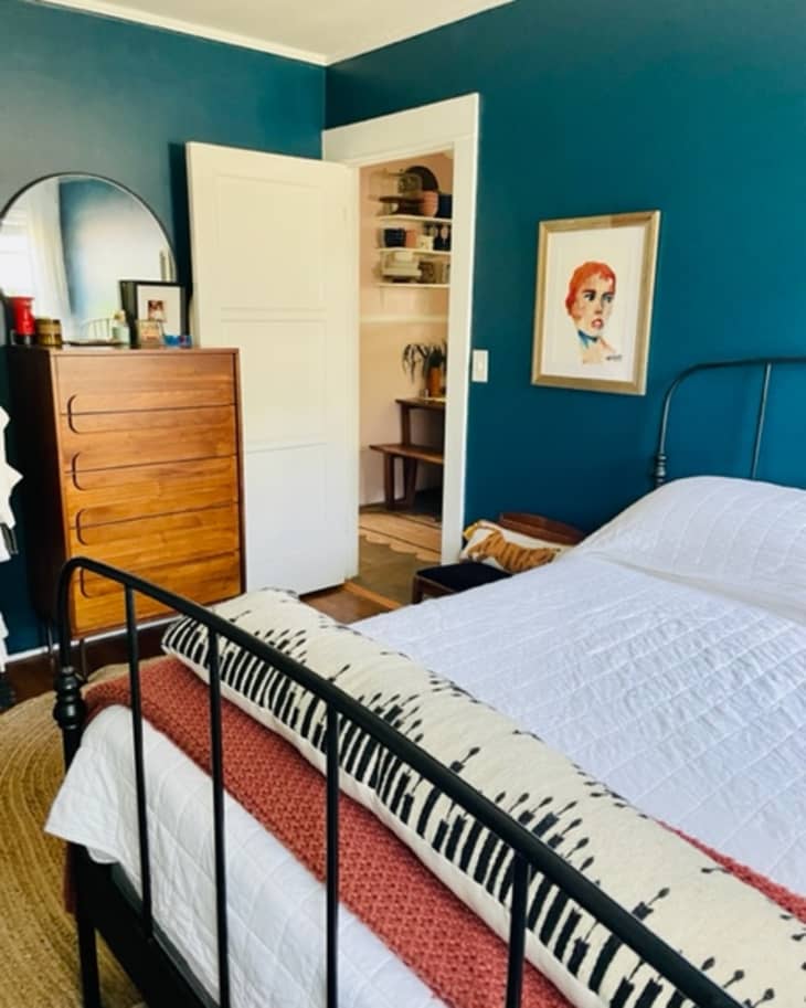 Blue bedroom with art and dresser