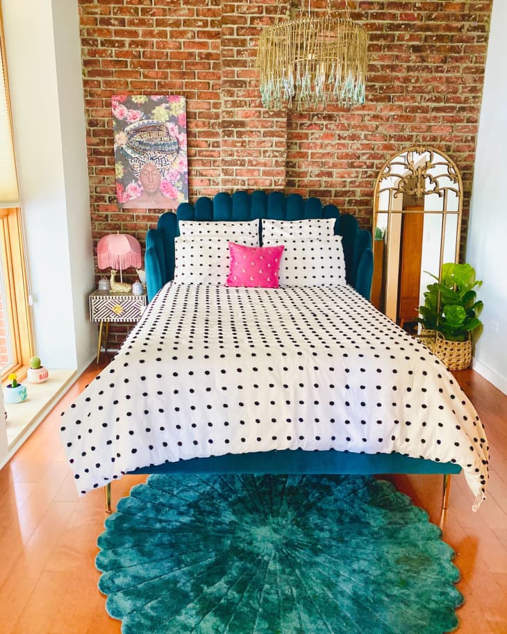 Bedroom with polka dot duvet and brick wall