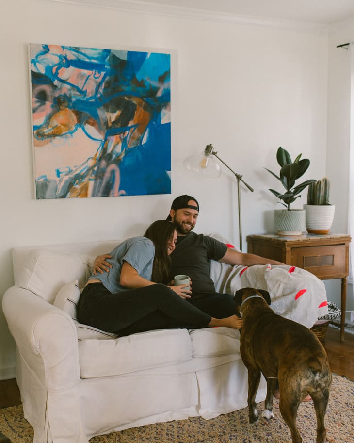 Sydney, her husband, and their dog in the living room.