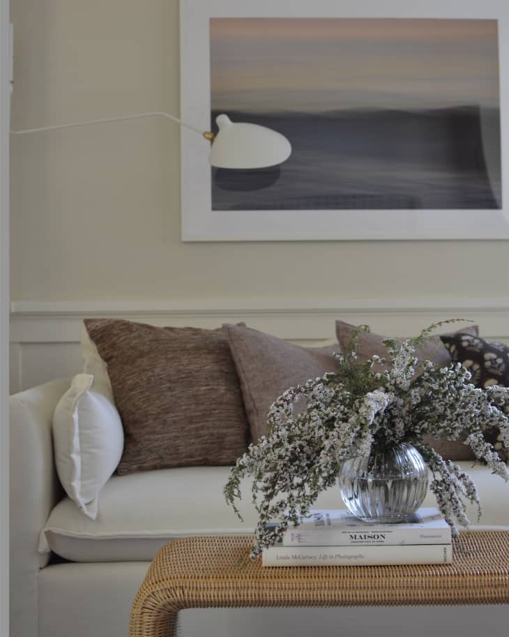 A white sofa underneath a photograph hanging on the wall