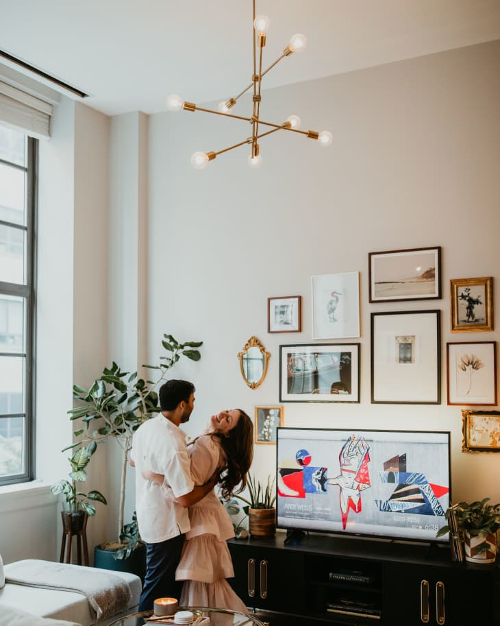Living room with a couple standing next to a gallery wall