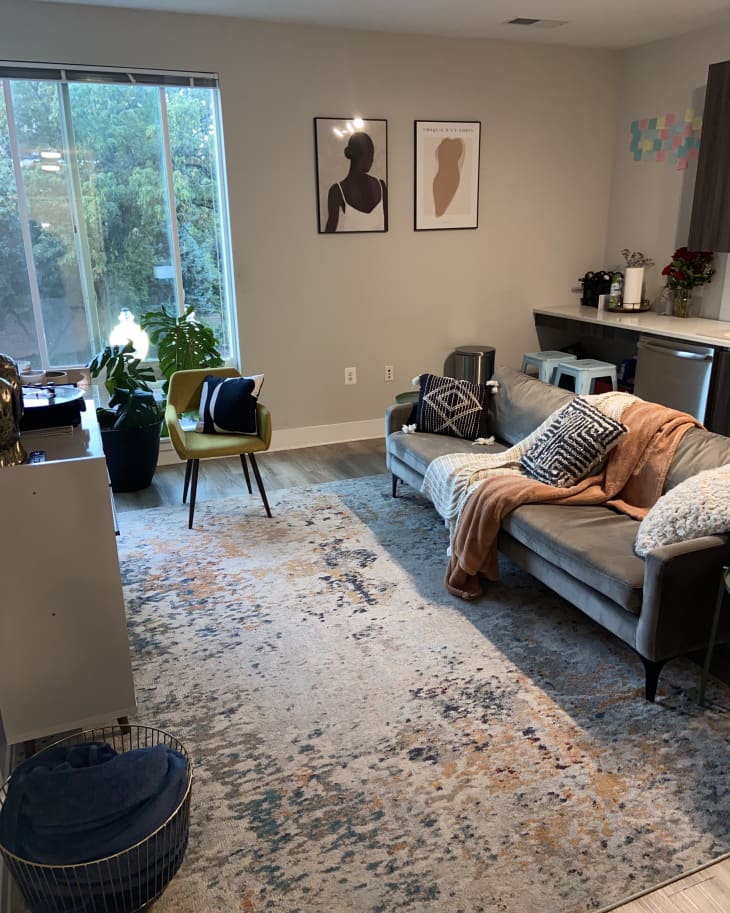 A living room with a gray couch and blankets on top