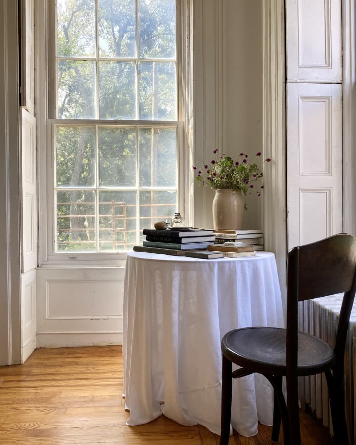 A round table with a long white table cloth draped over