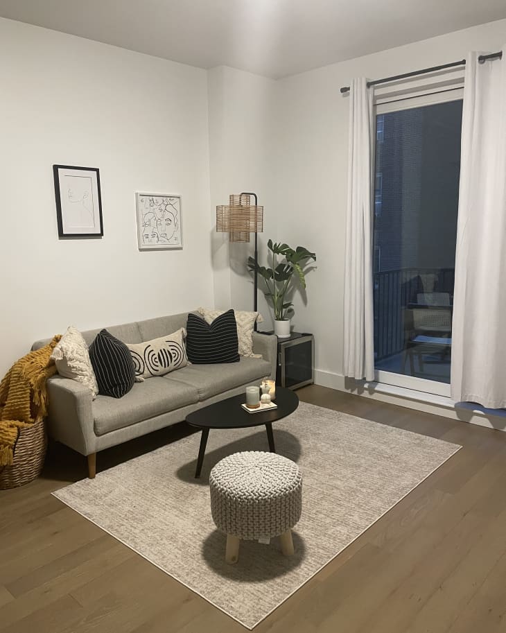 A gray sofa with a coffee table and rug