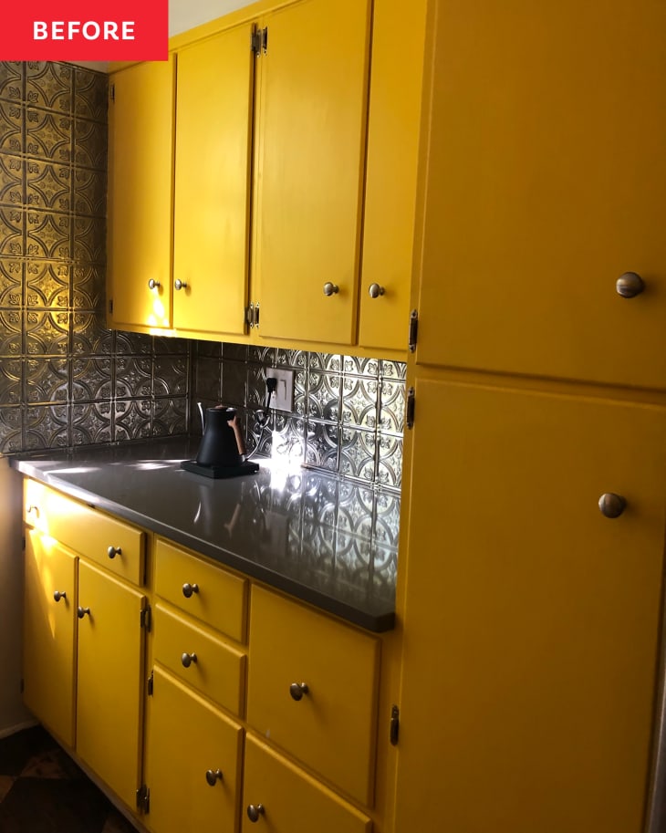 Bright yellow kitchen cabinets with silver tin wall tiles before a renovation