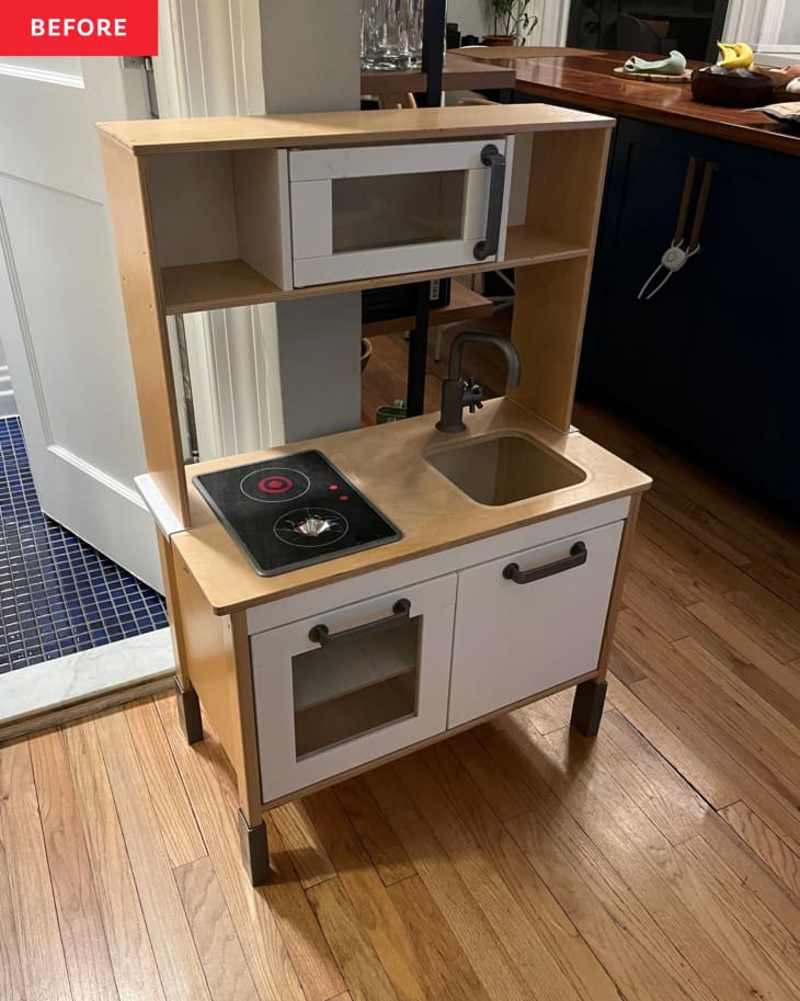 white and wood kids play set with built in microwave and black stove top