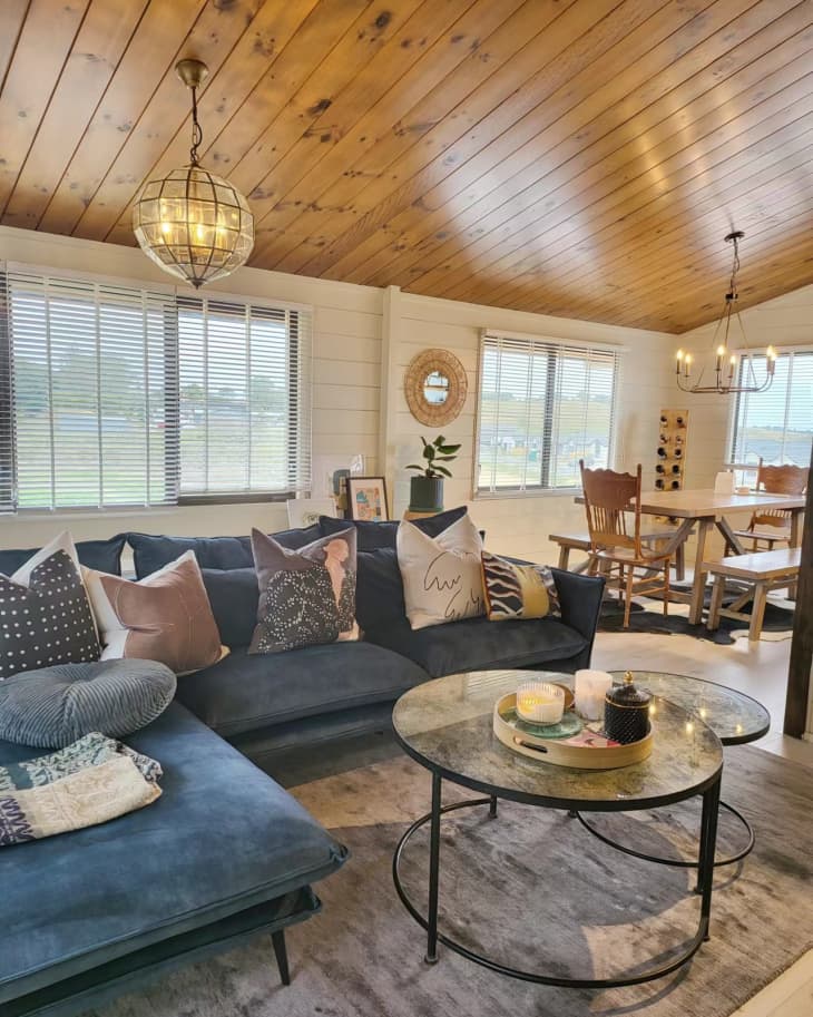 A living room with a large blue sectional sofa and a round coffee table