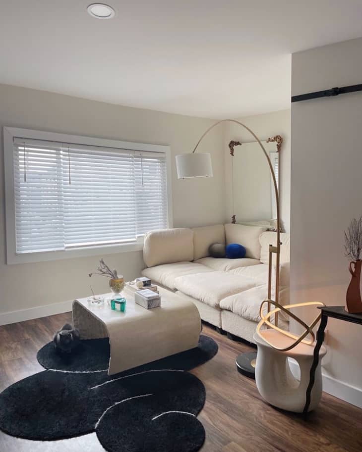 A living room with a white sofa and white walls