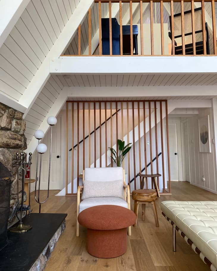 A living room with a white chair and the upper floor on display