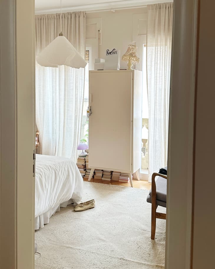 Scalloped pendant hung in light filled bedroom.
