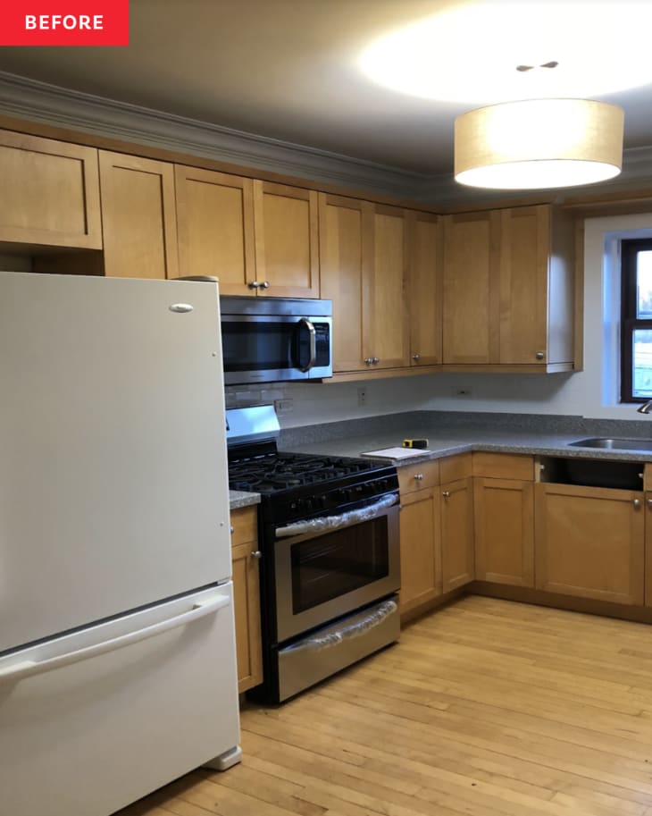 wood cabinets, wood floor, fridge, oven, grey countertops, large round lighting fixture