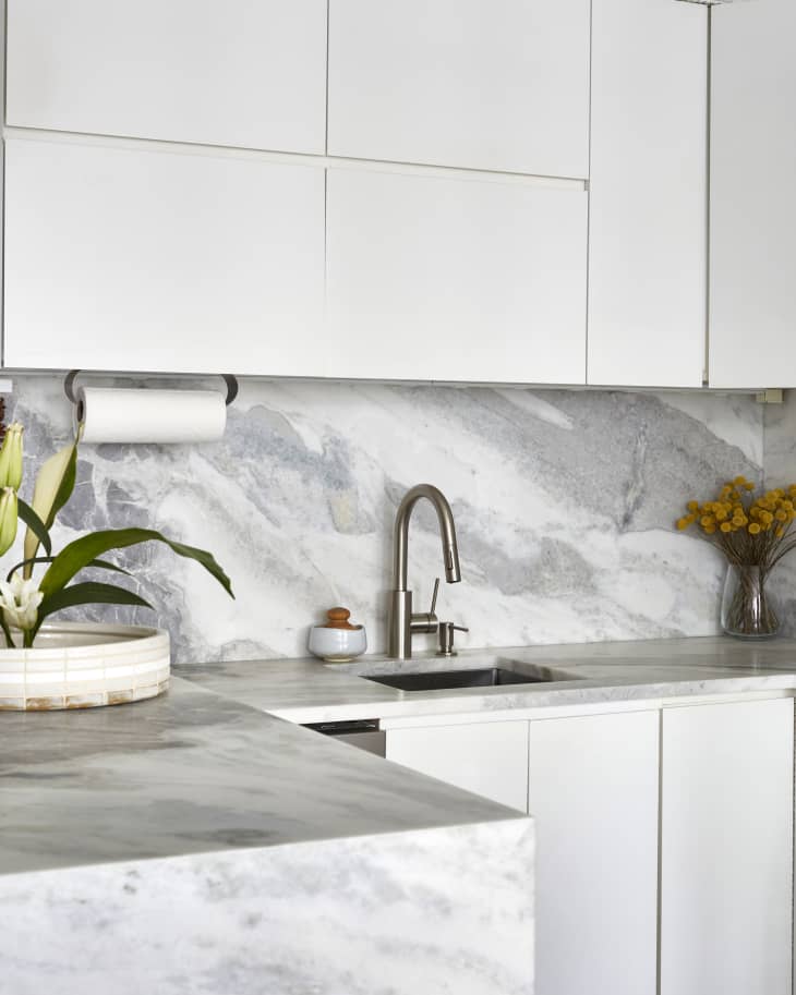 Kitchen marble counters/backsplash sink detail with white cabinets