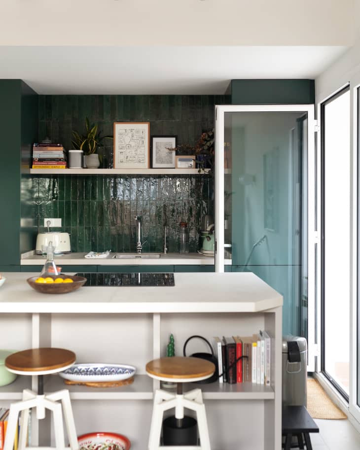 Green with green cabinets, green backsplash, and a white island.