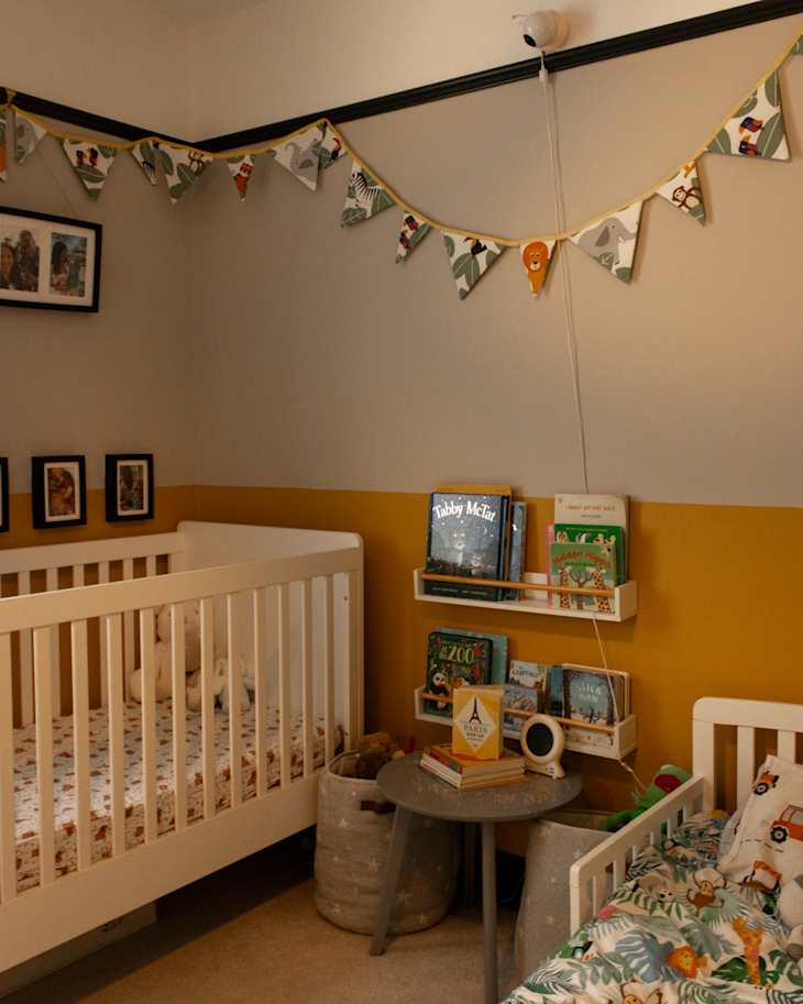 Crib and books in yellow and white children's room