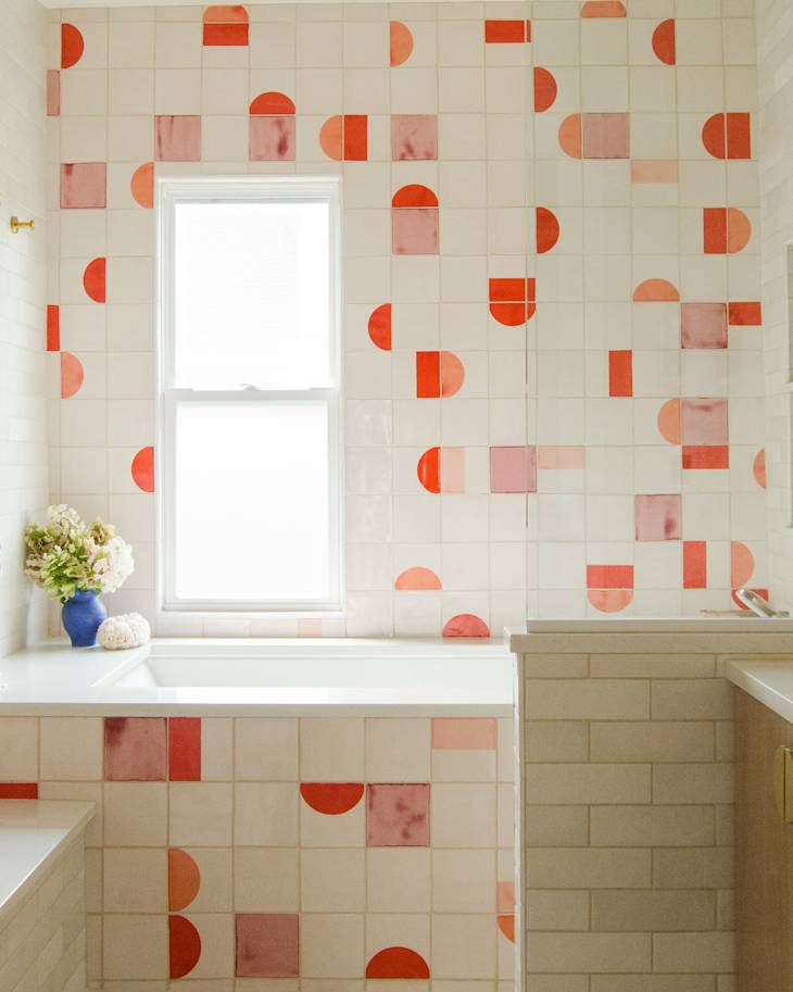 Kids bathroom with colorful feature tile wall, cream tile, white quartz countertops