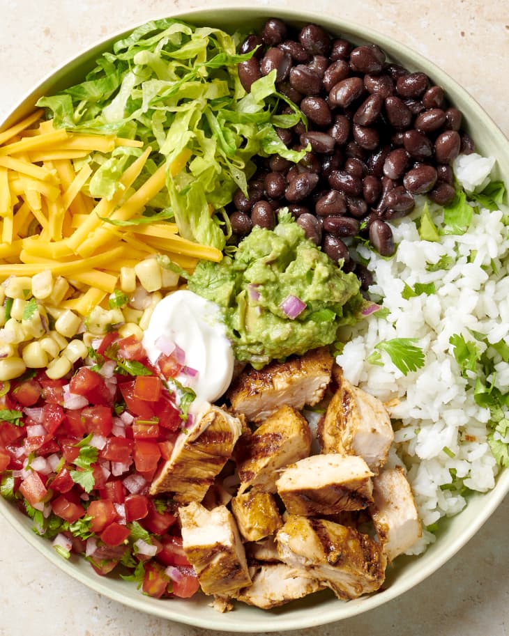 a burrito bowl with all of the elements separated into sections of the bowl