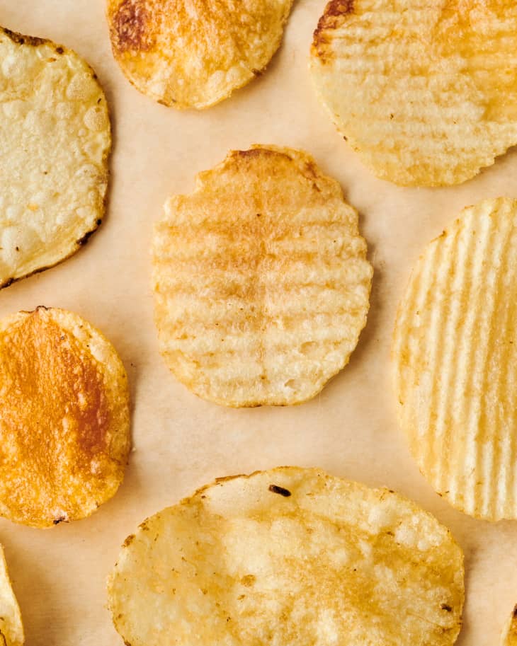 Various types of potato chips on a surfaces.
