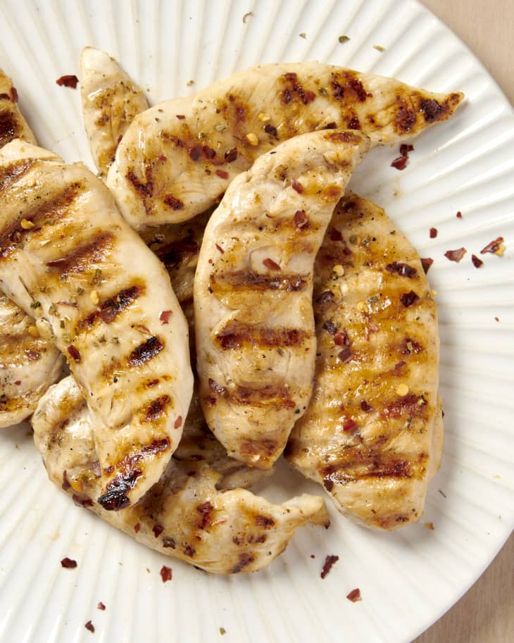 close up overhead shot of grilled chicken tenders on a white plate