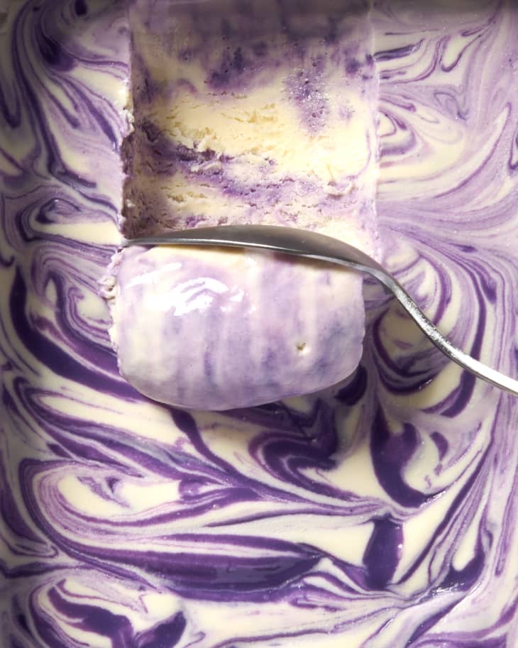 closeup overhead shot of silver spoon scooping ube swirl ice cream