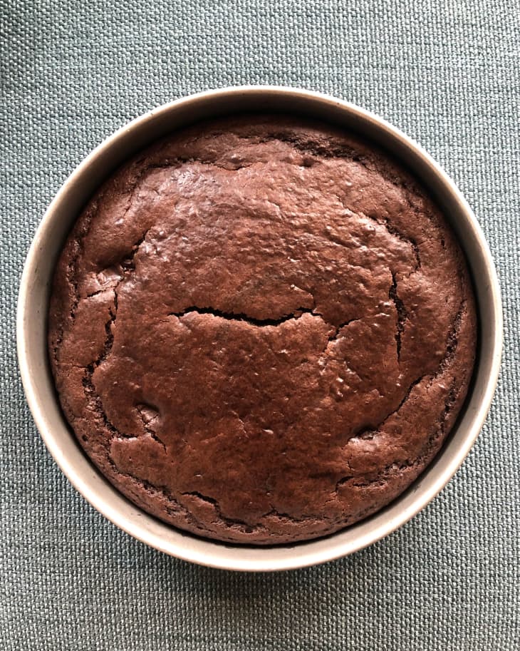 Finished cocoa yogurt cake sits on top of a blue and gray linen