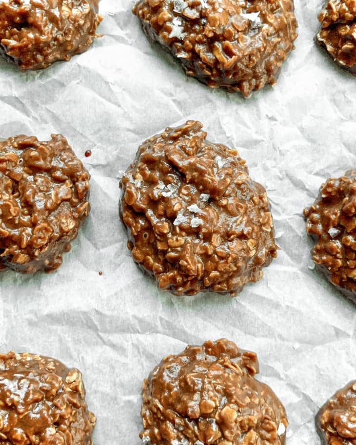 no bake cookies are spead out on white parchemnt paper