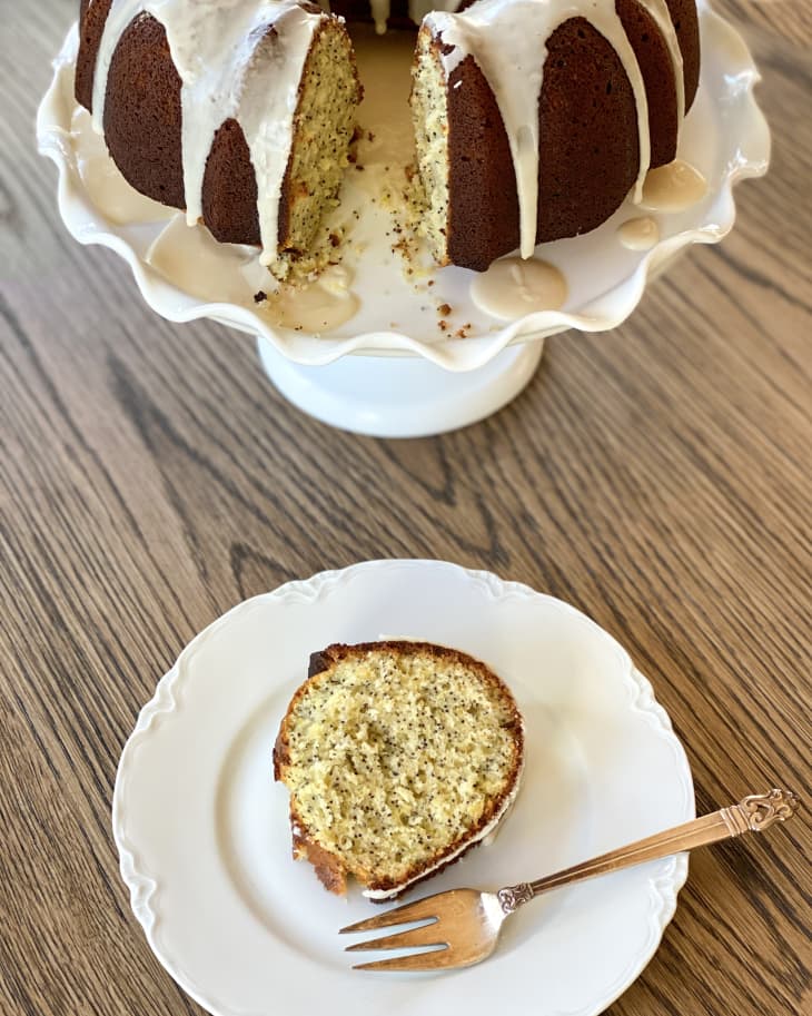 slice on a plate in front of lemon poppyseed cake