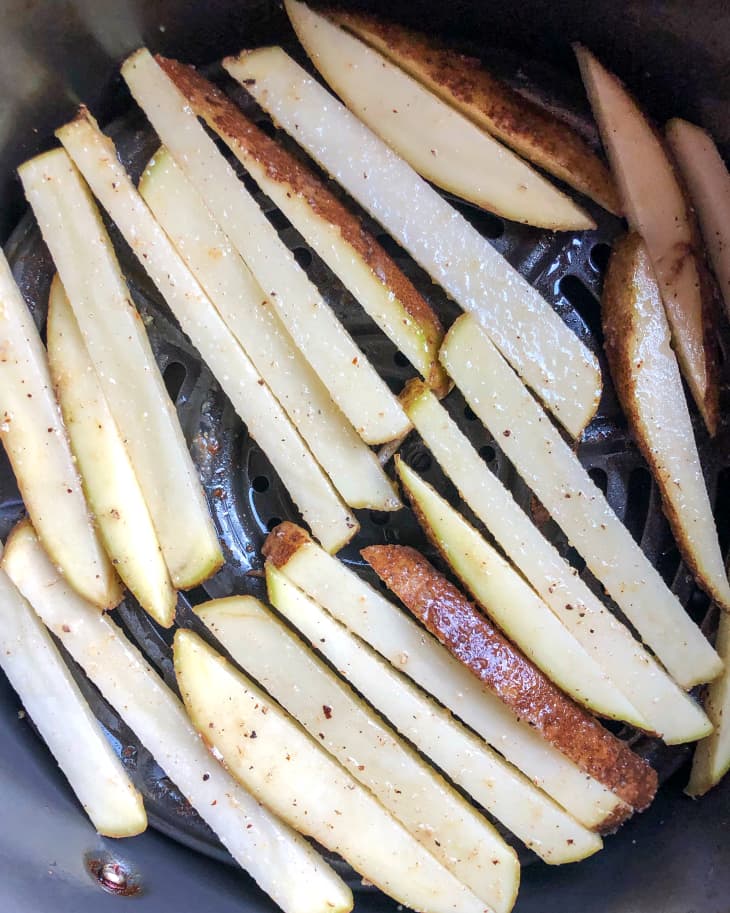 french fries sit uncooked in an air fryer