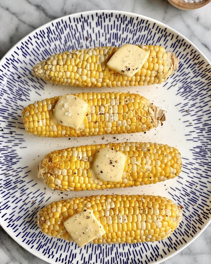 buttered air fryer corn on the cob on blue and white plate