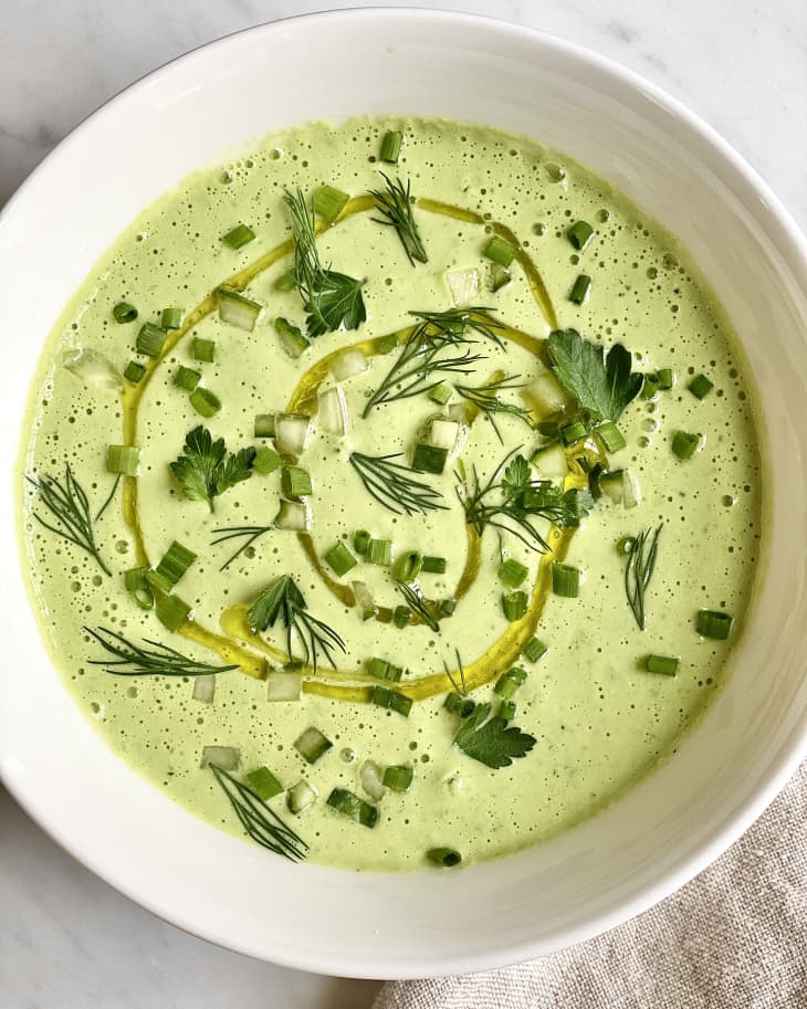 cucumber soup in bowl with olive oil and herbs