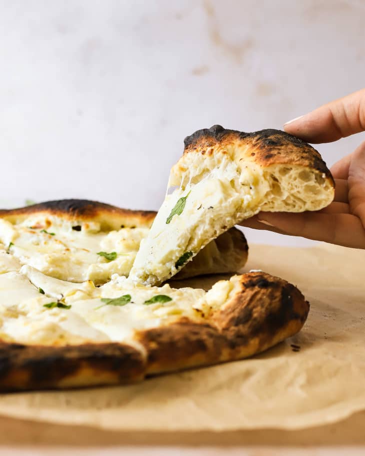 Photograph of white pizza on a piece of parchment paper.