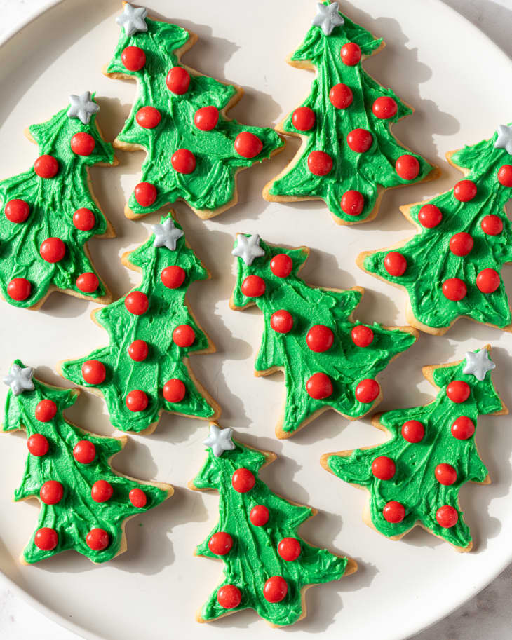 Photograph of Christmas tree cookies on a white plate.