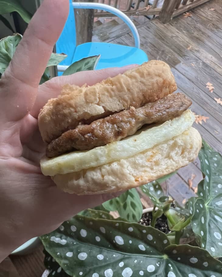 person holding a cooked Mason Dixie cheddar breakfast sandwich