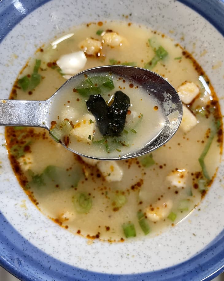 Miso soup made with instant miso balls ladled on a spoon.