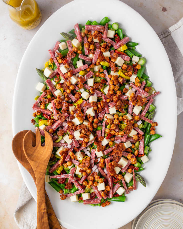 Big Springtime Chopped Salad on platter with serving utensils beside.