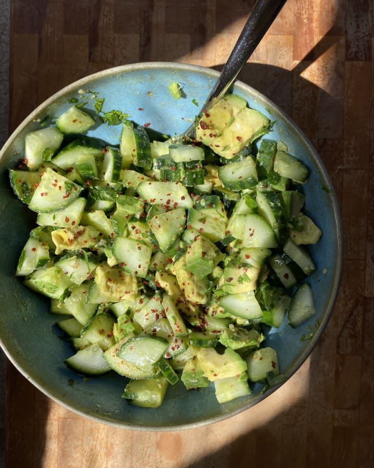 Cucumber avocado salad in bowl with fork on the side.