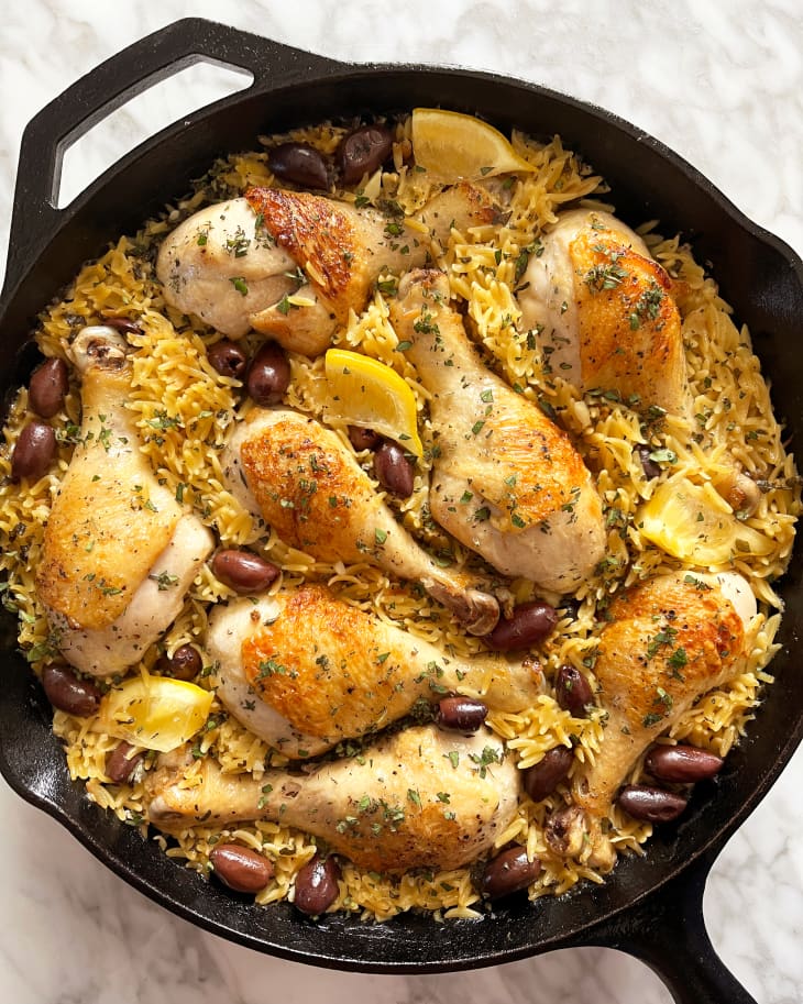 Chicken with lemon, rice, olives and herbs after cooking in skillet.