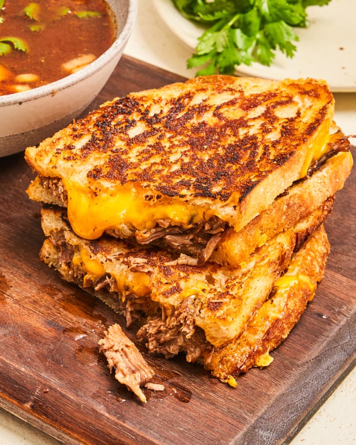 Birria grilled cheese sandwich cut in half and stacked on top of each other.
