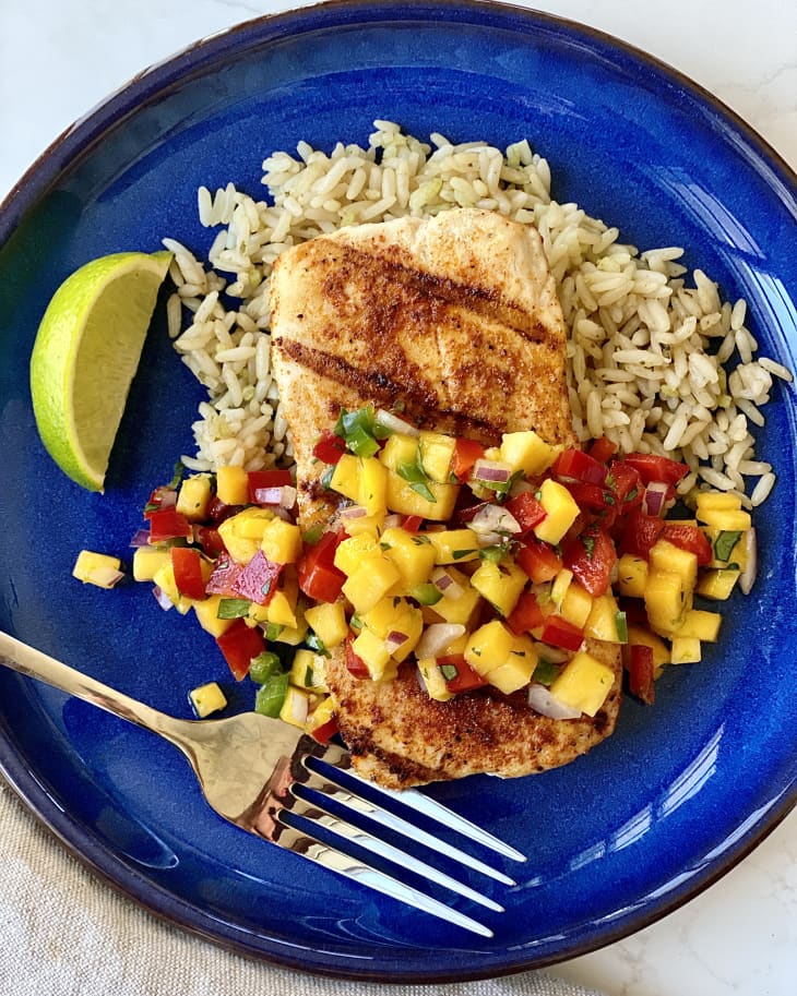 Grilled Mahi Mahi topped with mango salsa on a bed of rice.