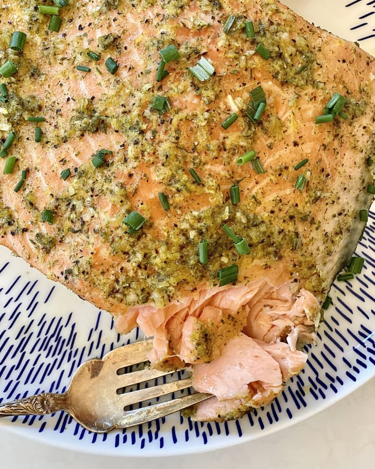 closeup of Slow-Roasted Green Goddess Salmon on plate, fork taking out a bite to show texture
