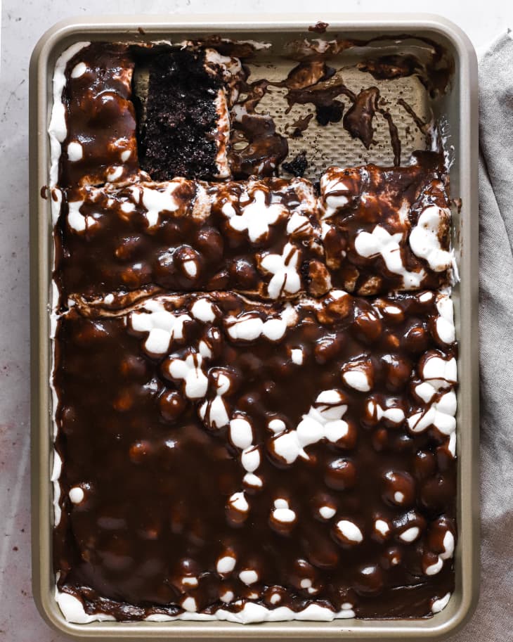 Mississippi mud cake in baking pan with slices out.