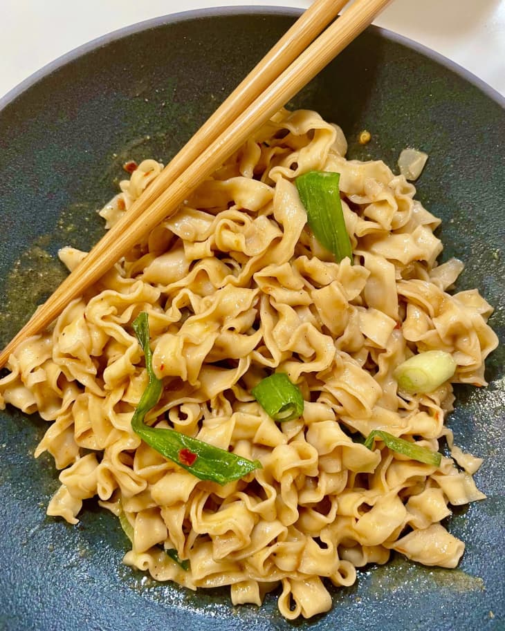 bowl of Omsom chili sesame noodles with chopsticks